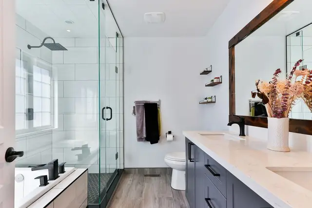 Baño con ducha de vidrio y mueble doble