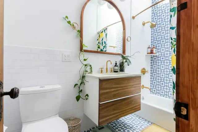 Baño con espejo de madera y azulejos decorados