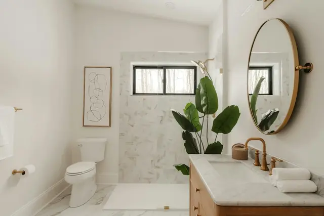 Baño con mármol y espejo redondo