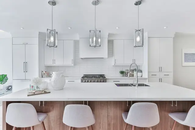 Cocina blanca con isla y banquetas