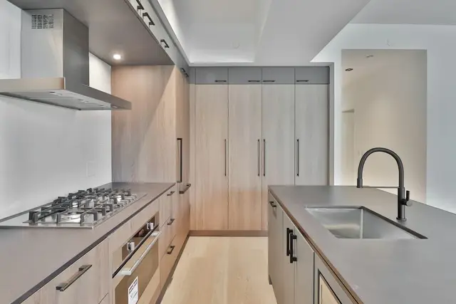 Cocina de madera clara con mesada de acero