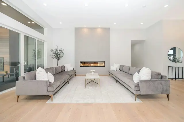 Living amplio con dos sofás y piso de madera