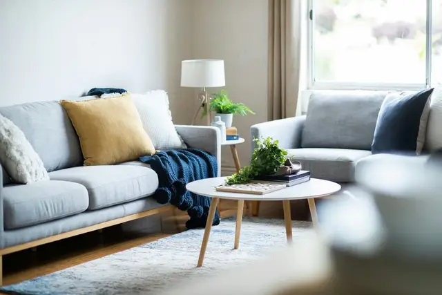 Living acogedor con sofá gris y almohadones